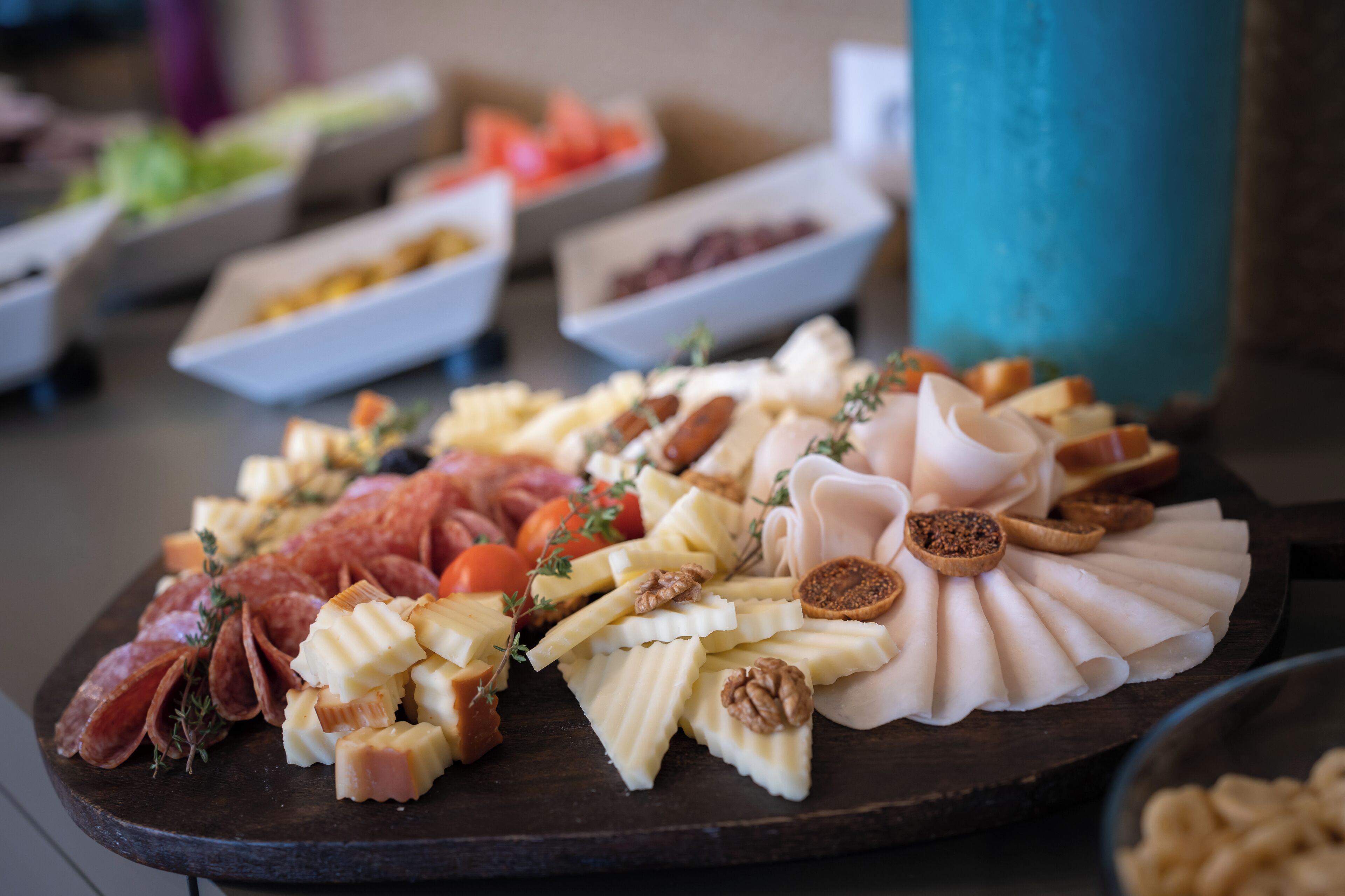A charcuterie board with various cheeses, meats, and accompaniments.