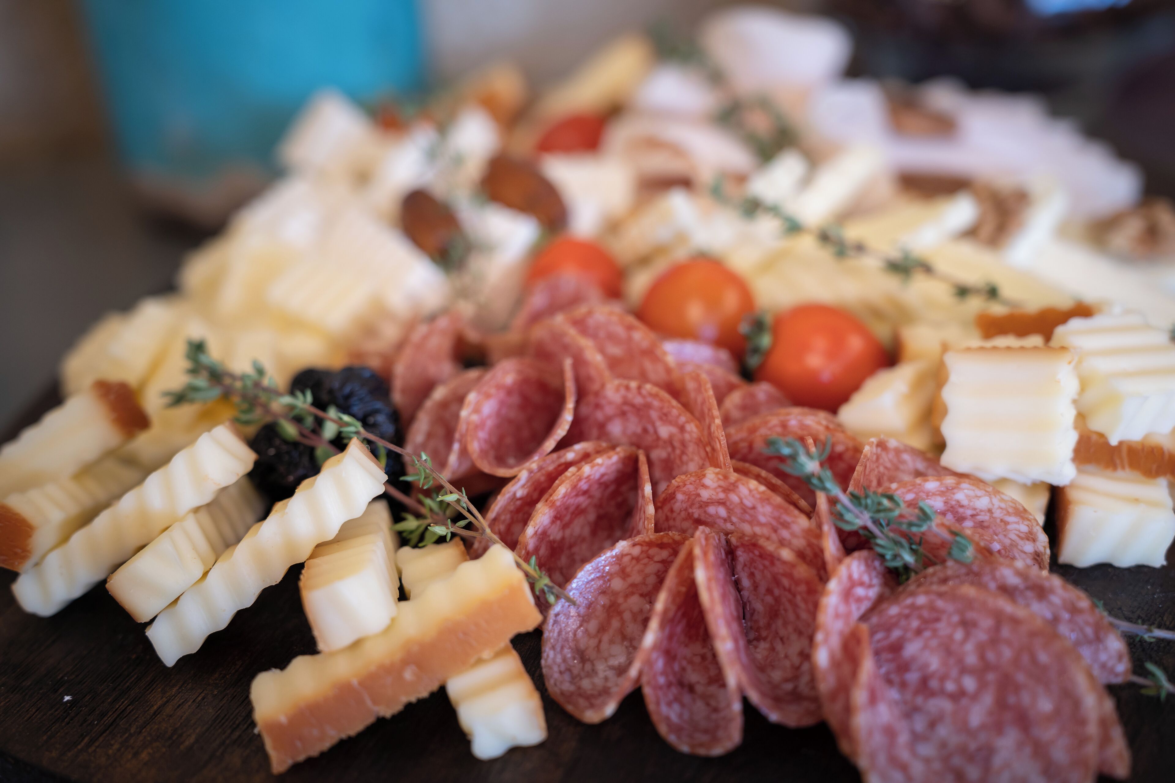 A charcuterie board with various meats, cheeses, and fruits.