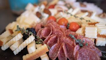 A charcuterie board with various meats, cheeses, and fruits.