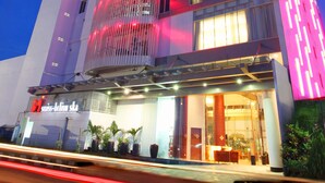 A modern hotel with a prominent vertical design, multiple floors, and a well-lit entrance. - Swiss Belinn SKA Pekanbaru (Pekanbaru)