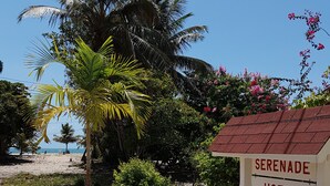 A sign for Serenade Hotel with a beach view. - Serenade Hotel (Placencia)