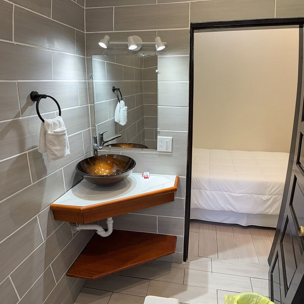 A modern bathroom with a large mirror, a vessel sink, and a wooden vanity.