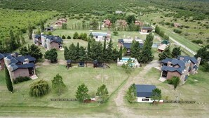 An aerial view of a residential area with multiple houses, a playground, and a swimming pool.