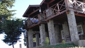 A multi-level stone building with a wooden balcony structure.