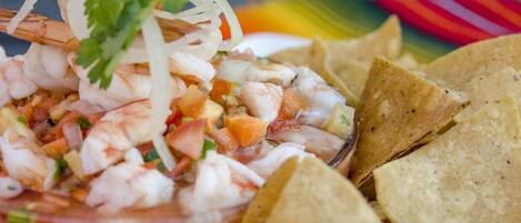 A shrimp cocktail with tortilla chips.
