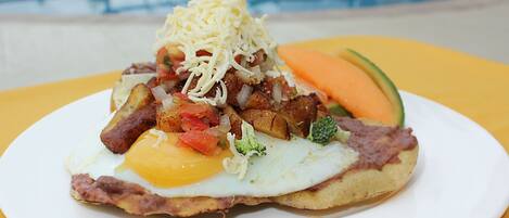 Un plato de comida con huevos, queso y verduras.