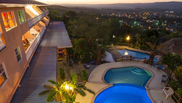 Ein Hotel mit Pool, Außenbereich und Blick auf die Stadt im Abenddämmerung.