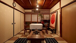 A traditional Japanese room with tatami flooring, a low table with a tea set, sliding doors, and a painting on the wall. - Hotobil (Nara)
