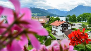 A building with a red roof, surrounded by greenery and a lake. - Hotel Askania (Bad Wiessee)
