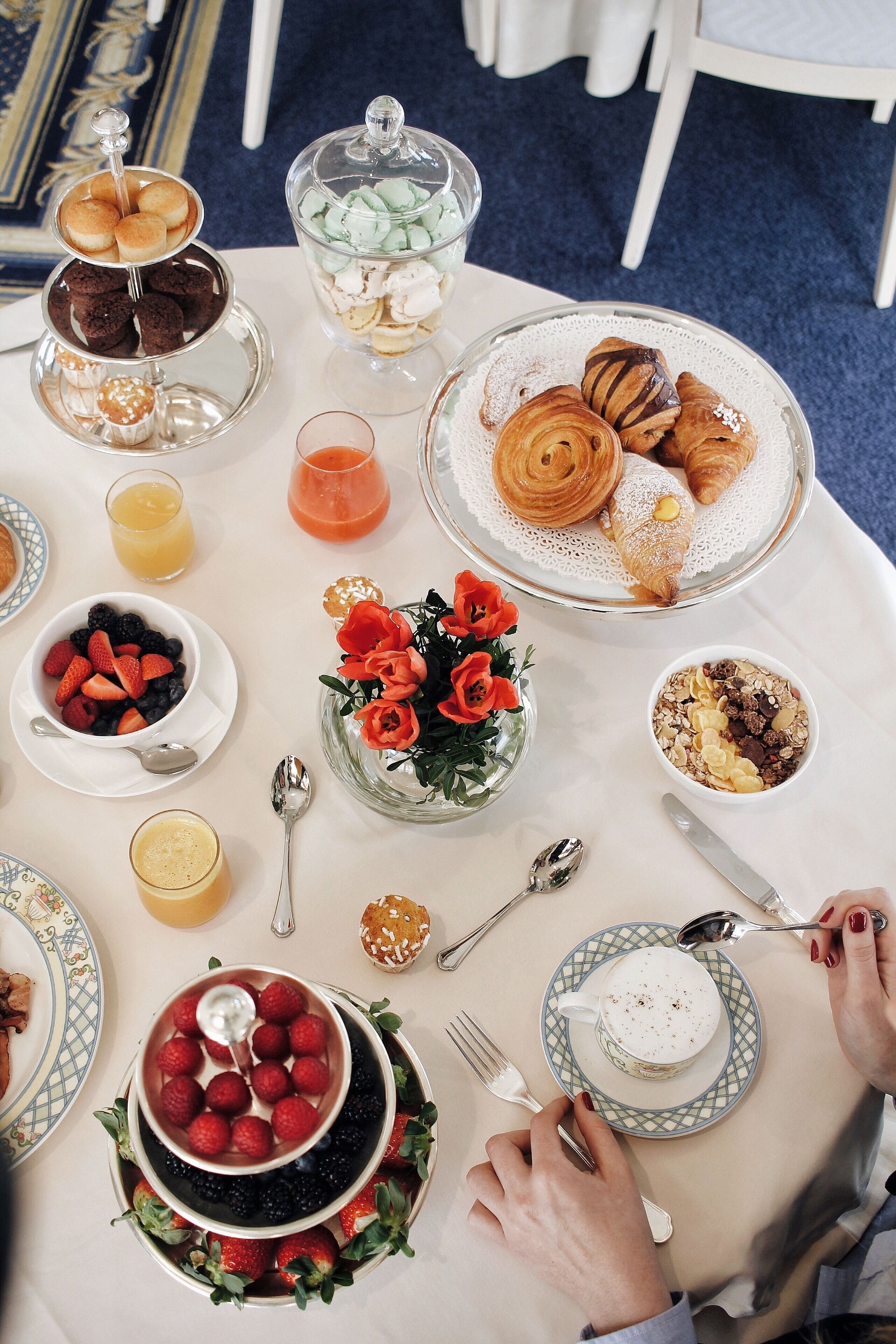 Una tavola imbandita per la colazione con dolci, frutta e bevande.