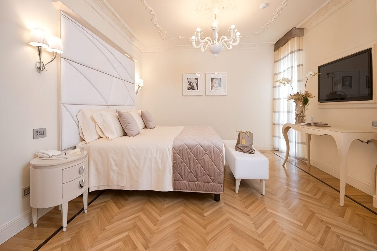 Una camera da letto con un letto, comodini, una scrivania e una televisione.