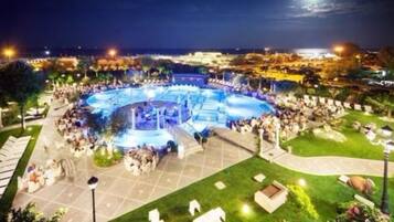 A large outdoor swimming pool with a circular design, surrounded by a well-maintained lawn and pathways.