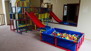 Kids can play and climb on the multi-colored play structure with slides and climbing elements.