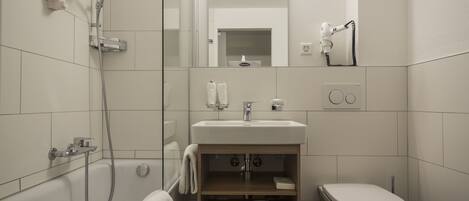 Une salle de bain moderne équipée d’une douche, de toilettes et d’un lavabo.