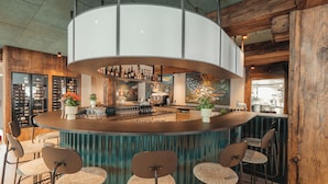 A bar area with a curved counter, multiple seating options, and a variety of bottles and glasses on display.