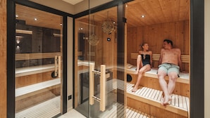 A sauna room with wooden benches and glass walls.