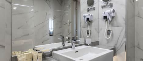 A modern bathroom with two large sinks, a hairdryer, and a mirror.