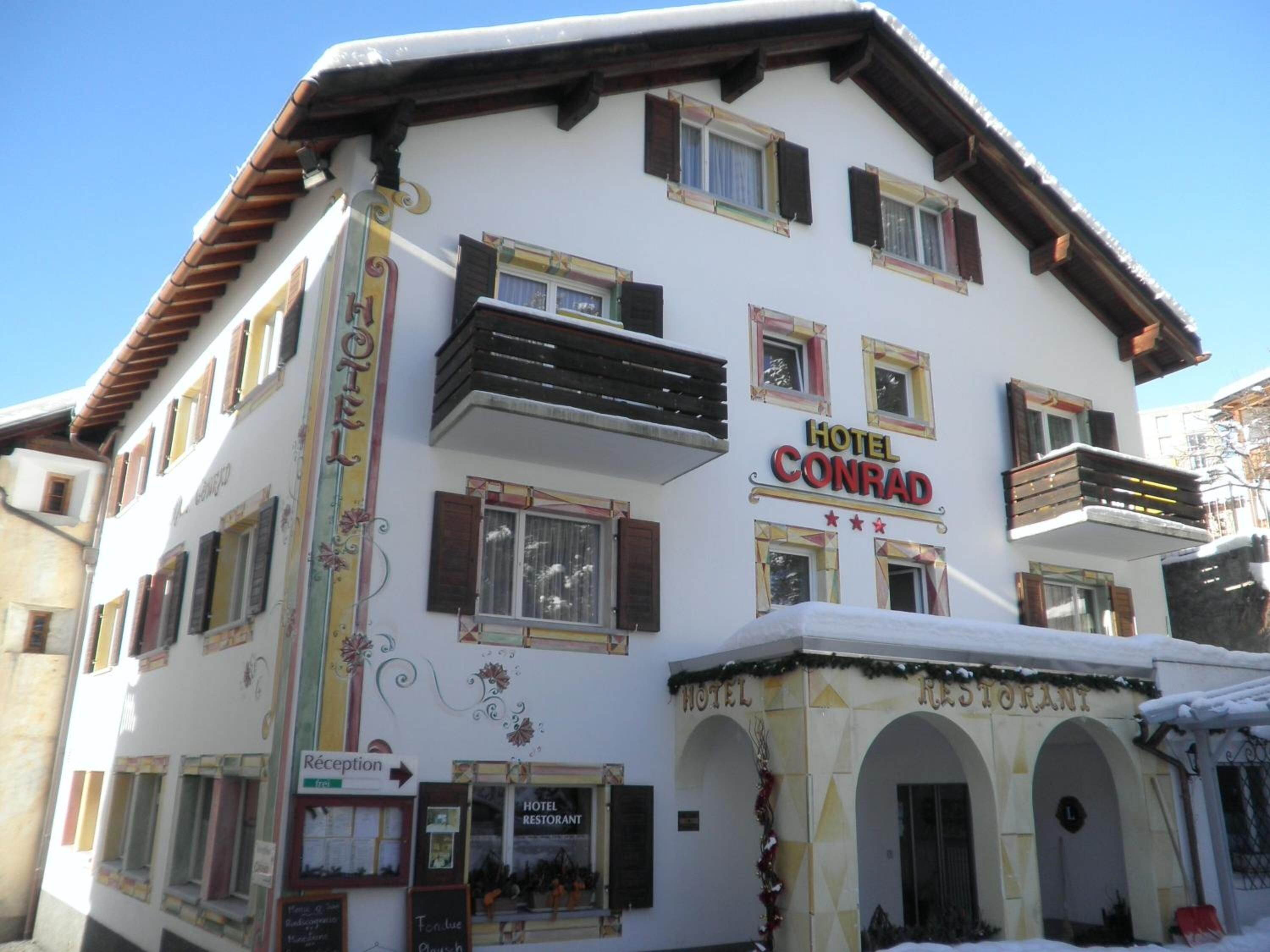 Un edificio de varios pisos con un letrero que dice "HOTEL CONRAD" y "HOTEL RESTAUNT".