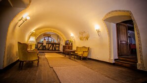 A cozy, well-lit interior with a vaulted ceiling, wooden furniture, and a view into another room. - Hotel Sighisoara (Sighisoara)