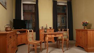 Habitació amb mobles de fusta, televisió i finestra amb cortines.