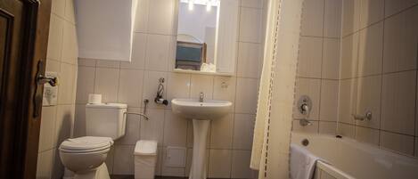 A bathroom with a toilet, sink, and bathtub.