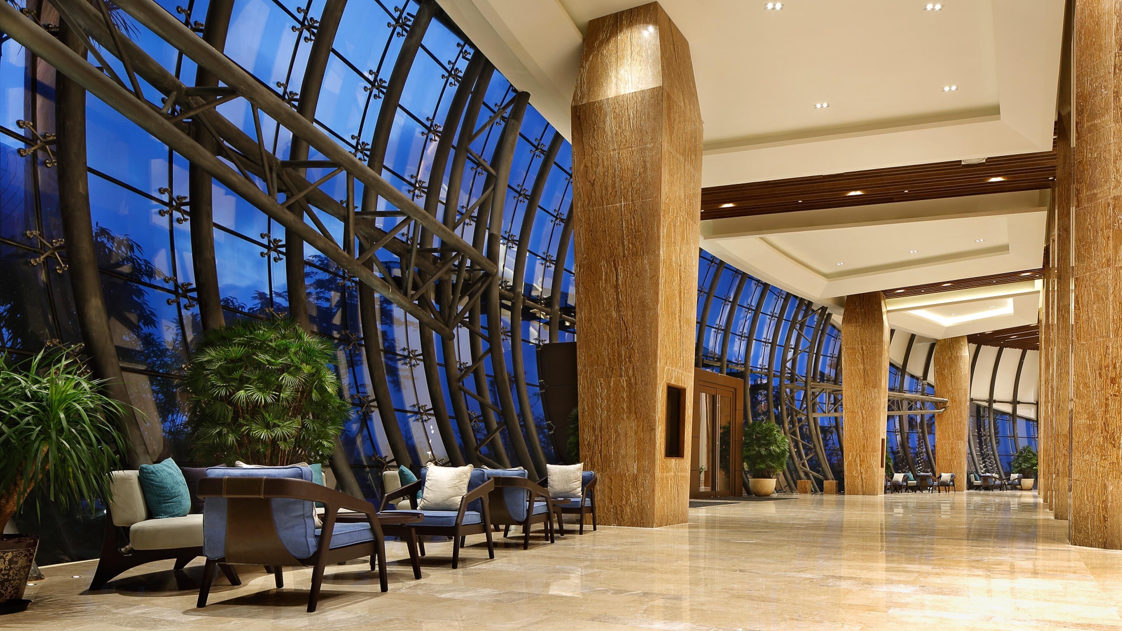 Eine großzügige Lobby mit hoher Decke, großen Fenstern und modernem Design.