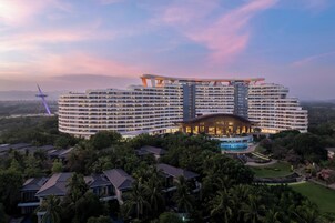 A large, multi-story hotel with a distinctive curved roof and a central atrium.