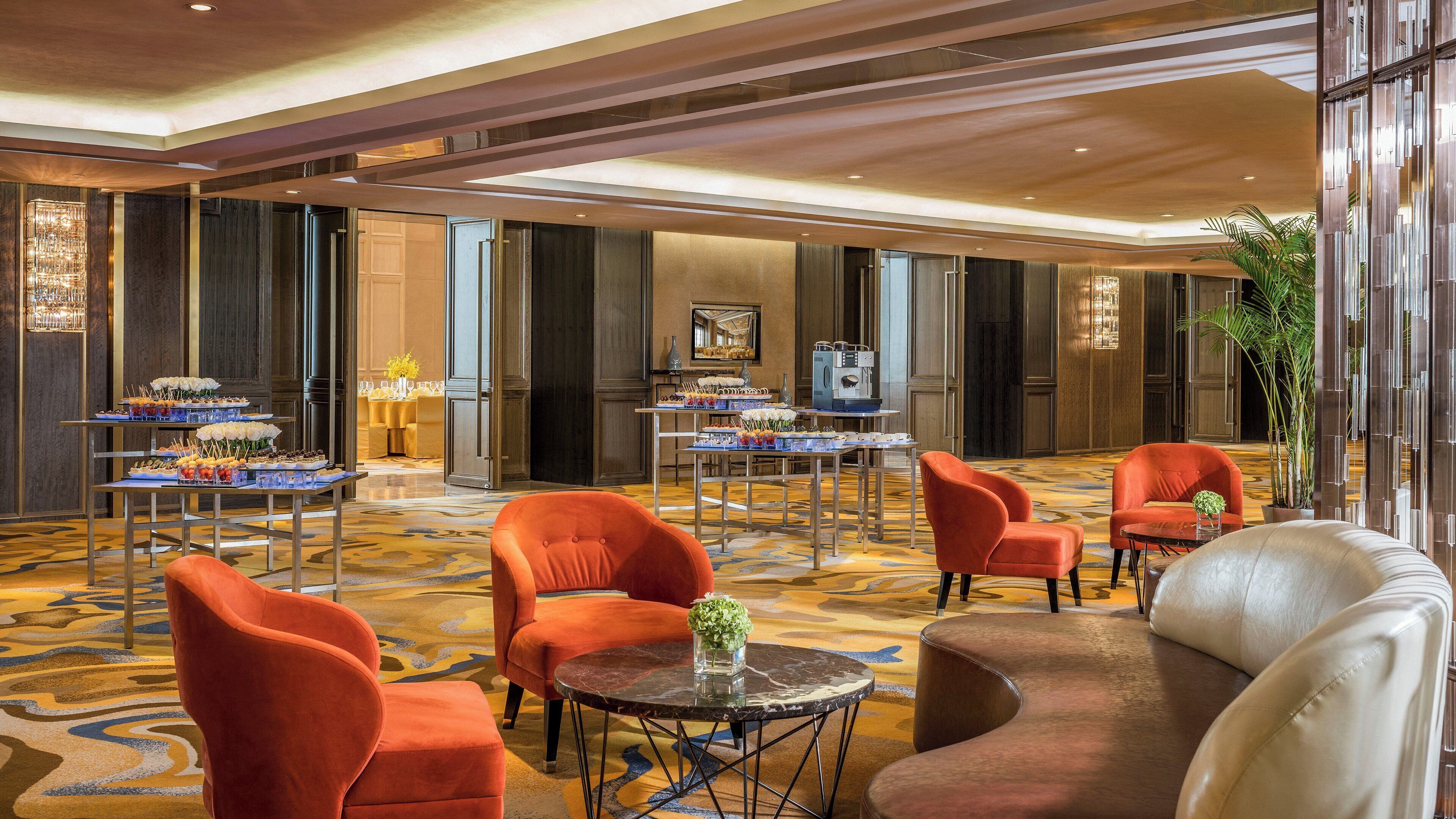 Un hall d’entrée spacieux avec un espace salon central, une table de buffet et un grand miroir.