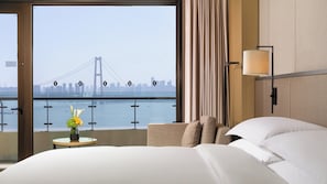 Una habitación de hotel con un ventanal que ofrece vistas a un puente y al horizonte de la ciudad.