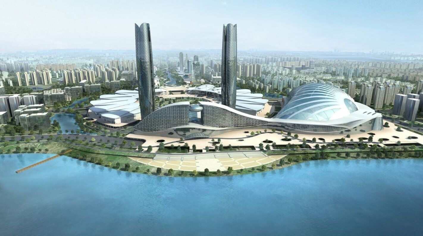 Un complejo arquitectónico futurista con varios edificios de gran altura, una estructura central en forma de cúpula y una masa de agua circundante.