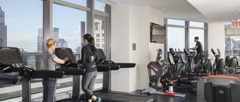 A gym with treadmills, elliptical machines, and weight equipment.
