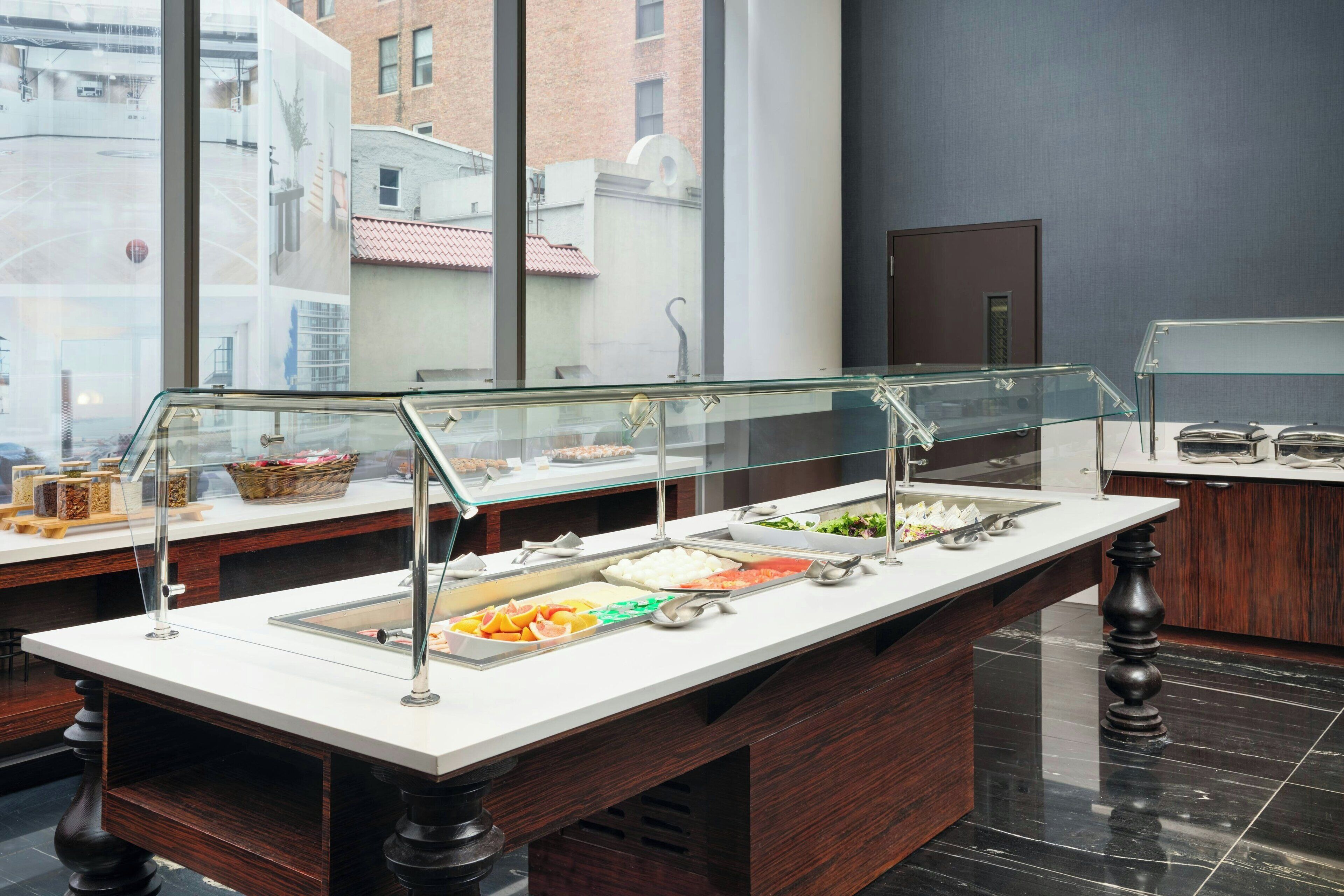 A buffet setup with various food items and a glass display case.