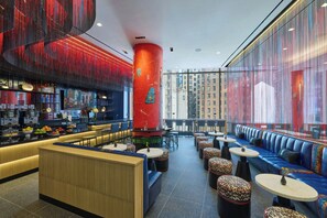 A modern bar area with seating and a large window overlooking a cityscape. - Residence Inn by Marriott New York Manhattan/Central Park (New York)