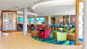A spacious lobby with modern furniture, a reception desk, and a dining area. - Springhill Suites by Marriott Bellingham (Bellingham)