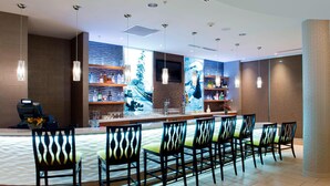 A modern bar area with a long counter, multiple chairs, and a large window with a view. - Springhill Suites by Marriott Bellingham (Bellingham)