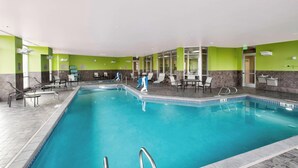 A swimming pool with lounge chairs and tables, surrounded by green and grey walls. - Springhill Suites by Marriott Bellingham (Bellingham)