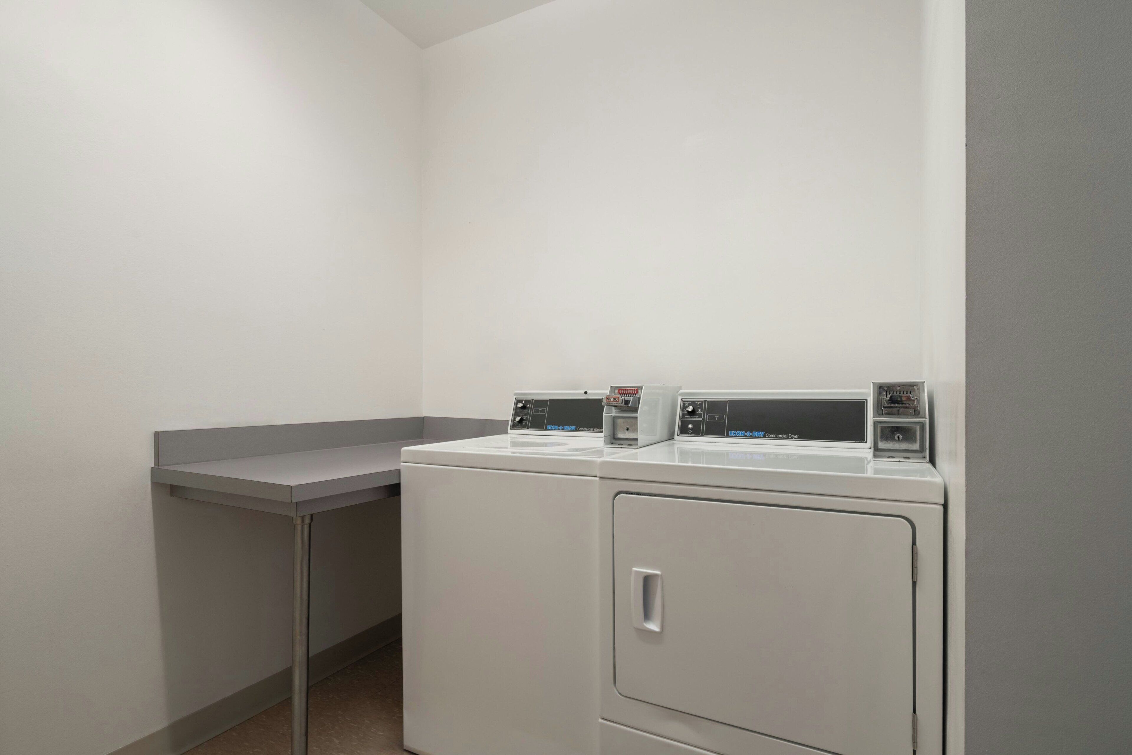 A laundry area with two stacked washers and a single dryer.