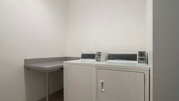 A laundry area with two stacked washers and a single dryer.