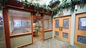 A room with a patterned carpet, wooden doors with decorative glass panels, and a small table with chairs. - Canad Inns Destination Centre Garden City (Winnipeg)