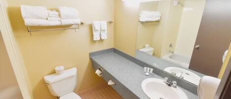 Baño con inodoro, lavabo, toallero y espejo.