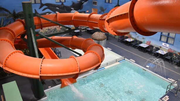 A pool area with a water slide and a mural of marine life. - Canad Inns Destination Centre Garden City (Winnipeg)
