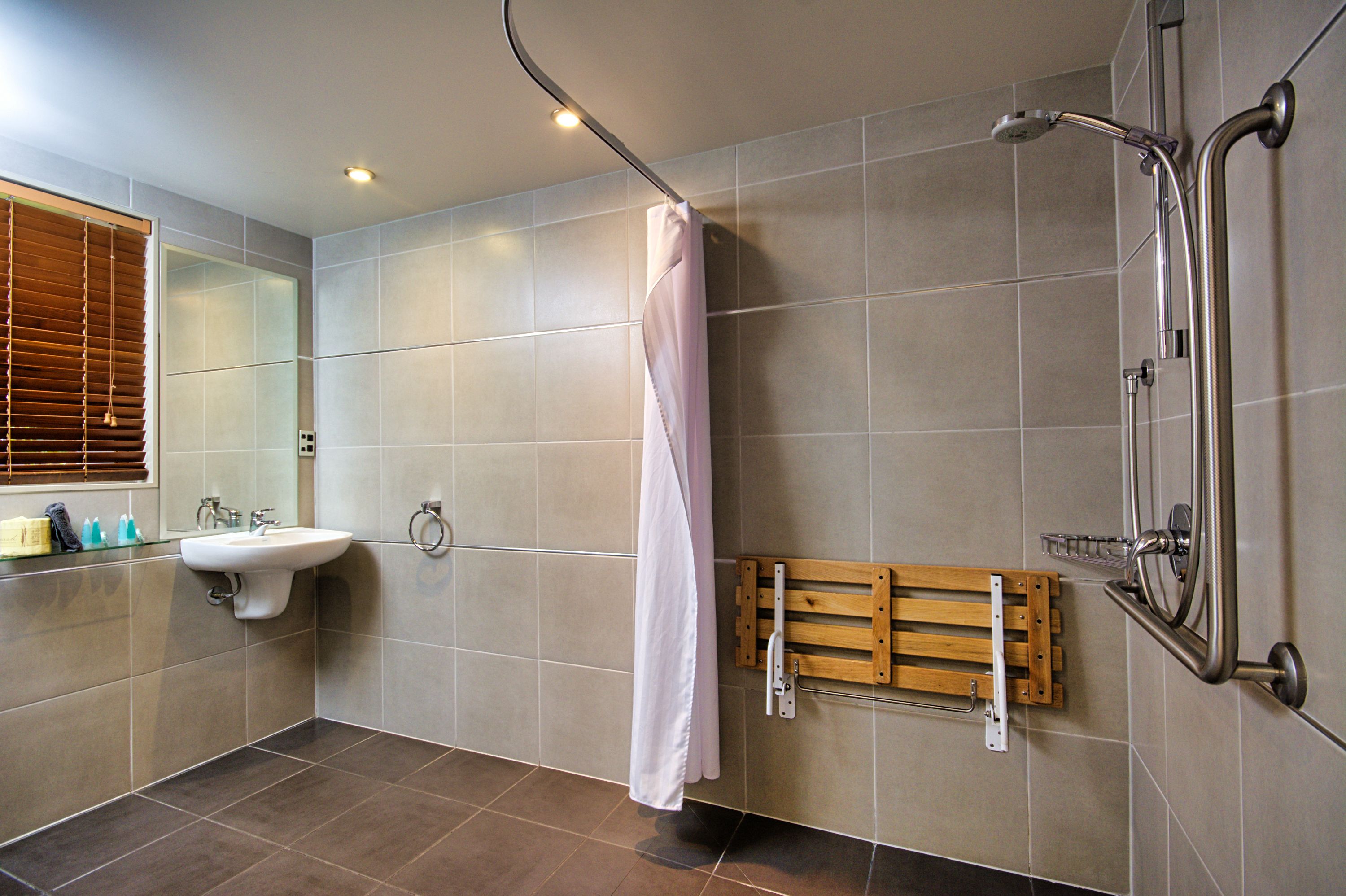 Ein modernes Badezimmer mit Waschbecken, Spiegel und Dusche.