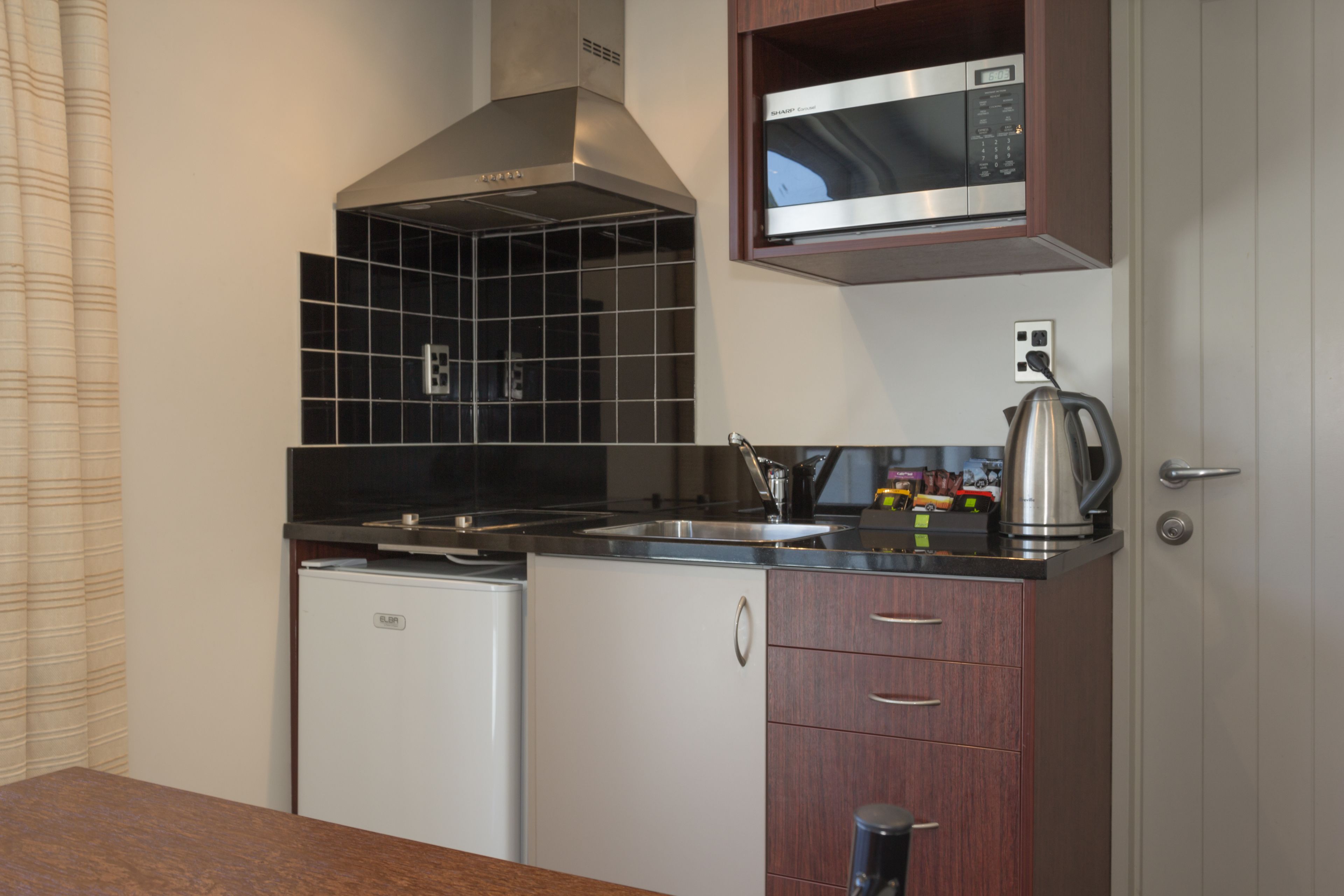 Una cocina compacta con microondas, estufa y lavavajillas.