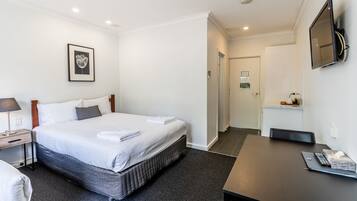 Escritorio, cortinas blackout y tabla de planchar con plancha