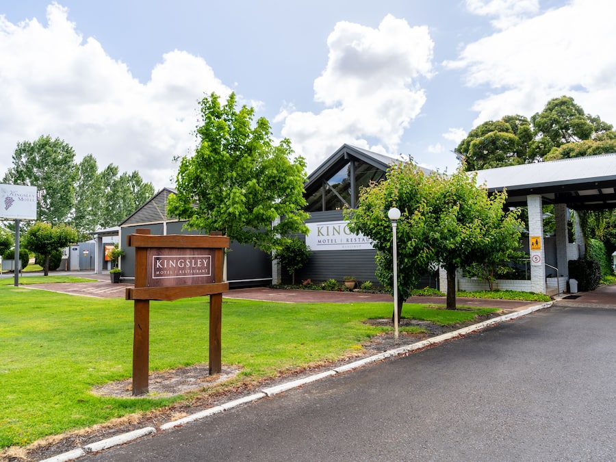 A Kingsley Motel with a signboard, a covered walkway, and a well-maintained lawn.