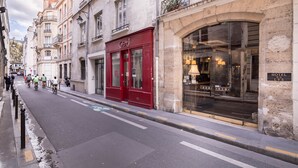 A street with a red building labeled "GBU" and a hotel entrance with a sign reading "HOTEL DU LYS." - Hôtel du Lys (Paris)