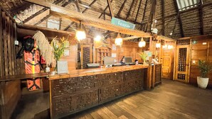 A reception area with a wooden reception desk, a sign reading 'Recepción,' and a receptionist behind the desk. - Hotel Amazon by On Vacation (Leticia)