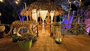A thatched-roof structure with a wooden bench and potted plants. - Hotel Amazon by On Vacation (Leticia)
