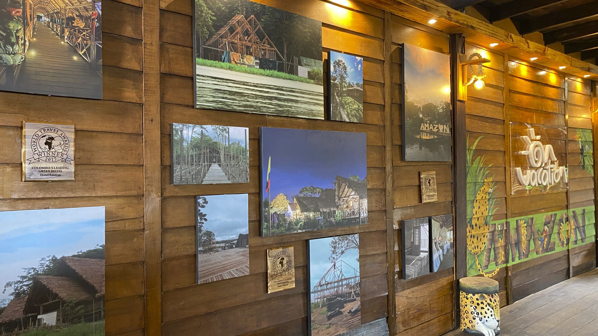 Una pared con varias fotografías enmarcadas de edificios y paisajes diversos, presumiblemente representando diferentes lugares o temas asociados al hotel.
