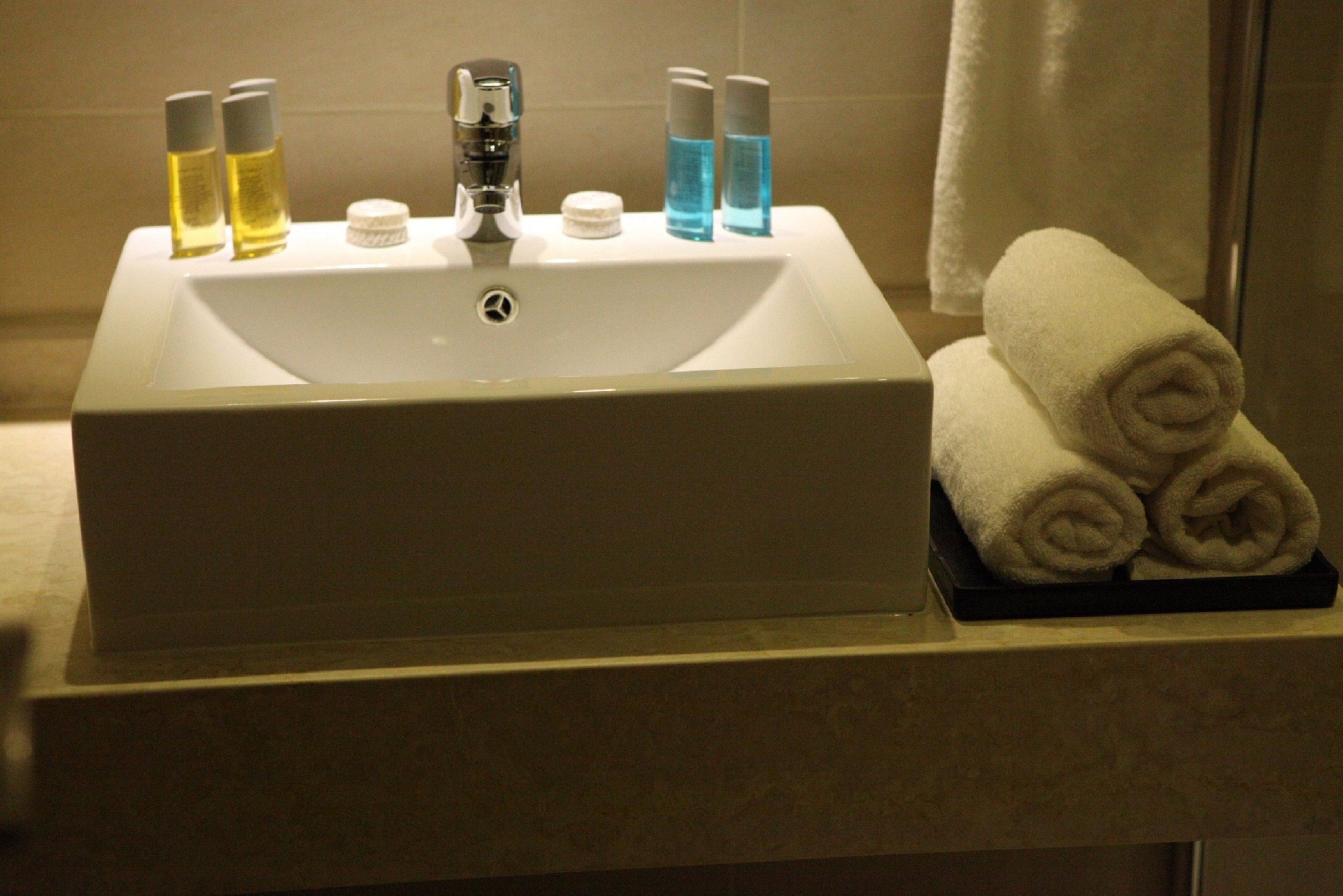 A bathroom sink with toiletries and towels.